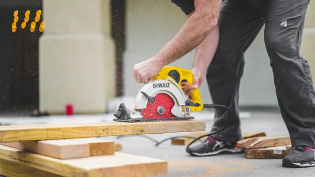 a%20contractor%20using%20a%20saw%20to%20cut%20planks%20of%20wood